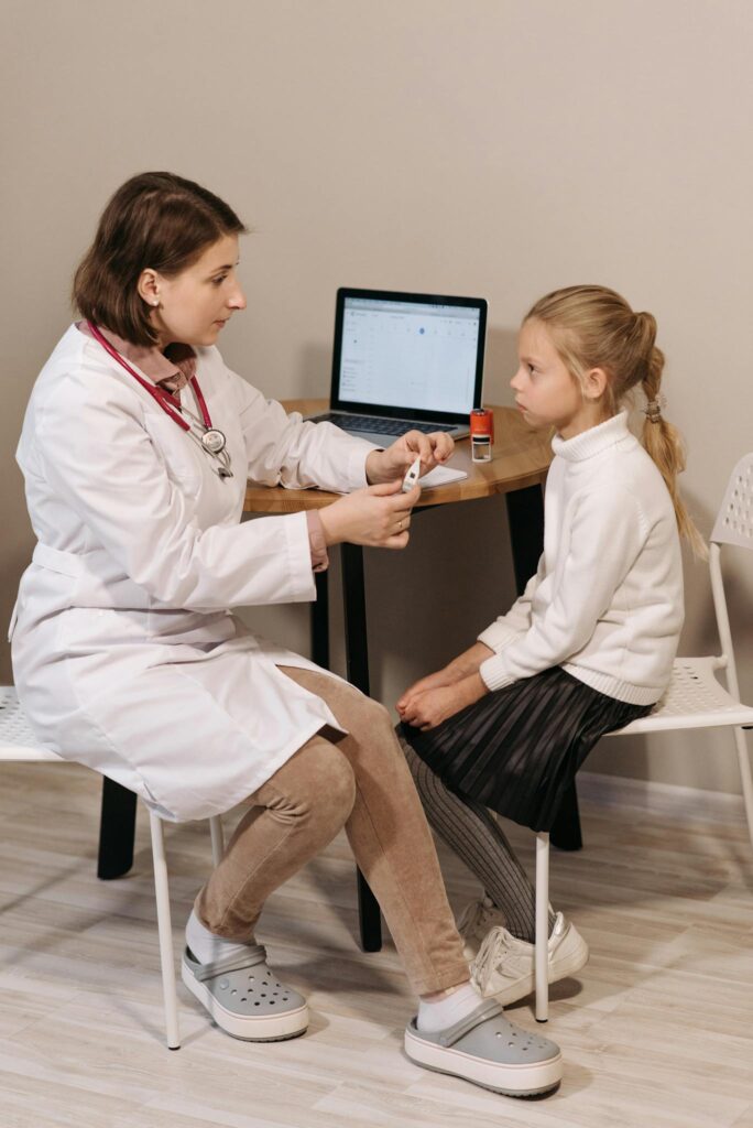Doctor conducting a consultation with a child in a medical clinic setting.
